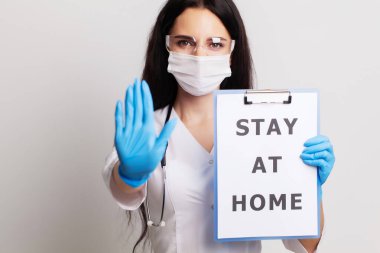 Eldivenli, maskeli ve gözlüklü doktor çarşafı elinde tutuyor.