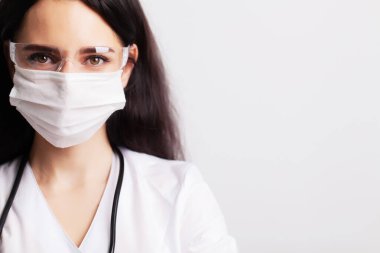 Çalışma alanında koruyucu gözlükleri ve steteskopu olan bir doktor.