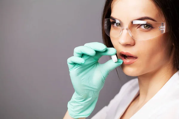 Médica feminina em luvas detém uma pílula para tratamento — Fotografia de Stock