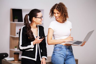 Takım çalışması süreci. Dizüstü bilgisayarlı iki kadın birlikte çalışıyor.