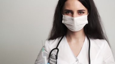 Eldivenli kadın doktor aşılı bir şırınga tutuyor.