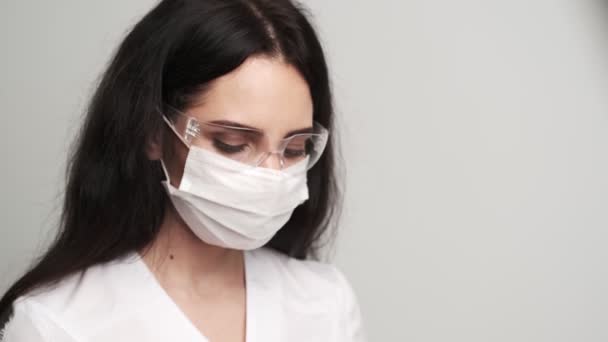 Médica feminina em luvas segurando um termômetro eletrônico . — Vídeo de Stock