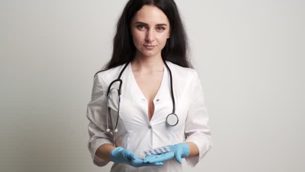 Kvinna läkare i handskar innehar piller för män sexuell hälsa. — Stockvideo