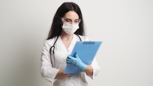 Médico con gafas protectoras y estetoscopio en su espacio de trabajo . — Vídeo de stock