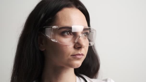 Çalışma alanında koruyucu gözlükleri ve steteskopu olan bir doktor.. — Stok video
