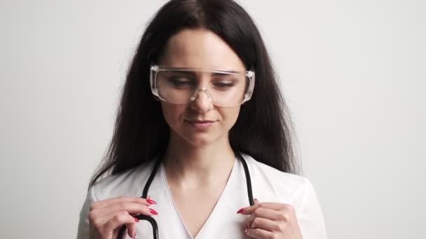 Läkare med skyddsglasögon och stetoskop på arbetsytan. — Stockvideo