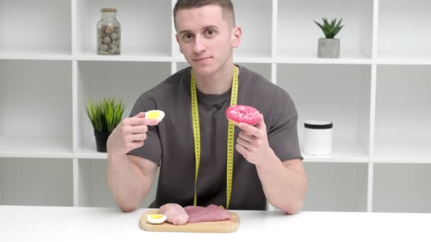 Zdravý stravovací koncept. Silný muž si vybírá mezi zdravým a nezdravým jídlem. — Stock video