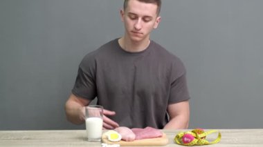 Sağlıklı beslenme konsepti. Atletik yapılı bir adam yüksek proteinli sağlıklı yiyecekler yer.