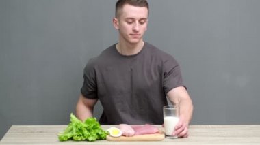 Sağlıklı beslenme konsepti. Atletik yapılı bir adam yüksek proteinli sağlıklı yiyecekler yer.