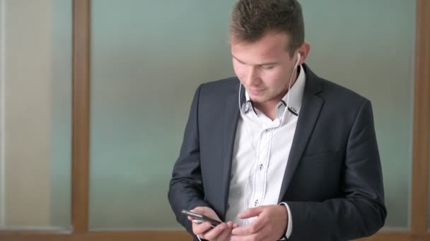 Biznesmen rozmawiający przez telefon przez słuchawki w biurze firmy — Wideo stockowe