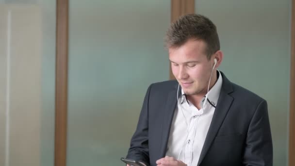 Biznesmen rozmawiający przez telefon przez słuchawki w biurze firmy — Wideo stockowe