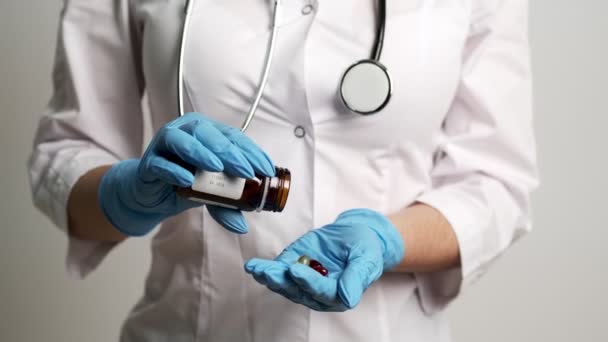 Medico femminile in guanti tiene una pillola per il trattamento . — Video Stock