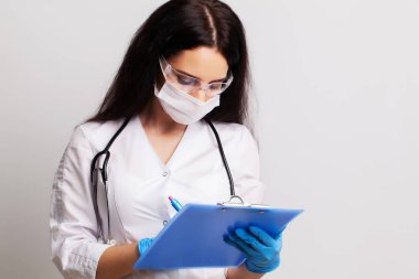 Tıp konsepti, klinikteki kadın doktor ayakta tedavi kartını dolduruyor