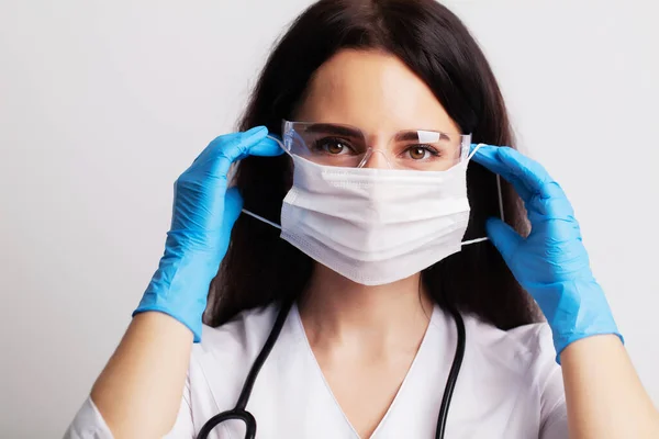 Conceito de medicina, médico coloca máscara cirúrgica protetora para proteção — Fotografia de Stock