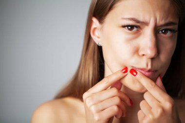 Sevimli kız banyoda aynanın önünde yüzüne sivilce sıktı.