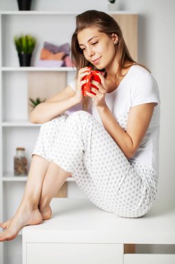 Yeni pijamaları içinde güzel bir gülümsemesi olan tatlı bir kız yatmaya hazırlanıyor.