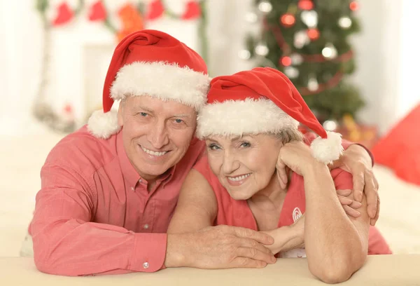 Starší pár v Santa klobouky — Stock fotografie