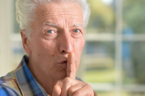 Senior uomo preme il dito sulla bocca — Foto Stock