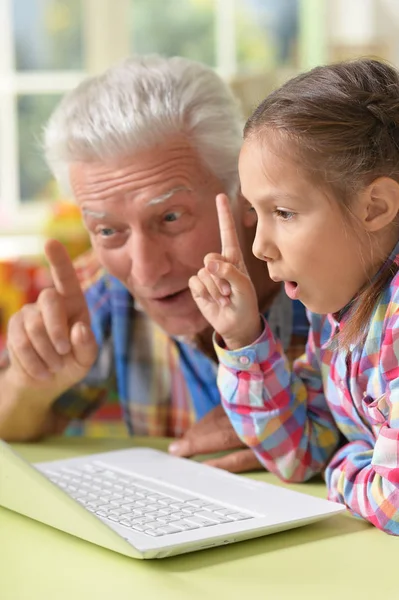 Grootvader en kleindochter met laptop — Stockfoto