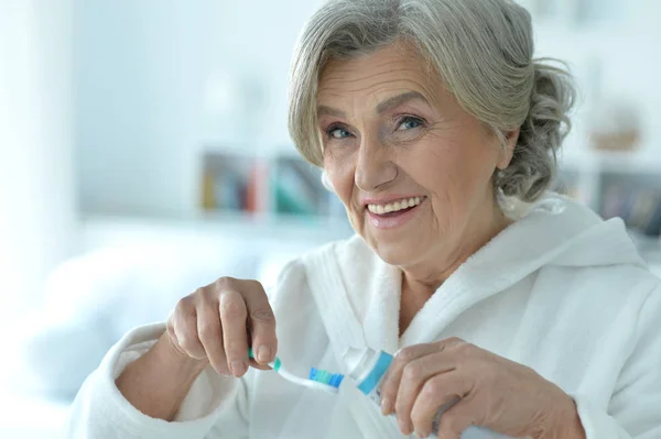 Senior vrouw haar tanden poetsen — Stockfoto
