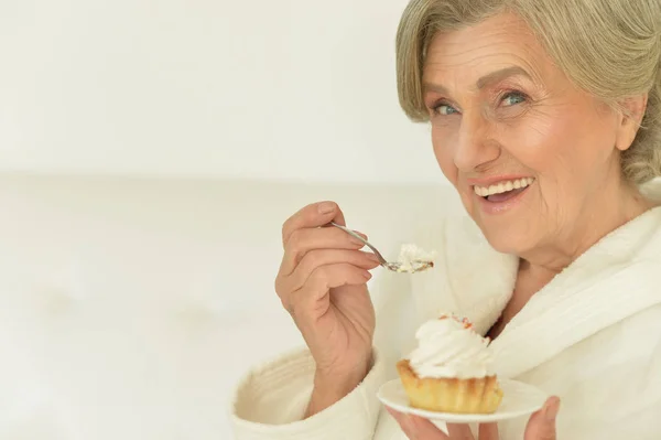 Seniour vrouw eet cake — Stockfoto