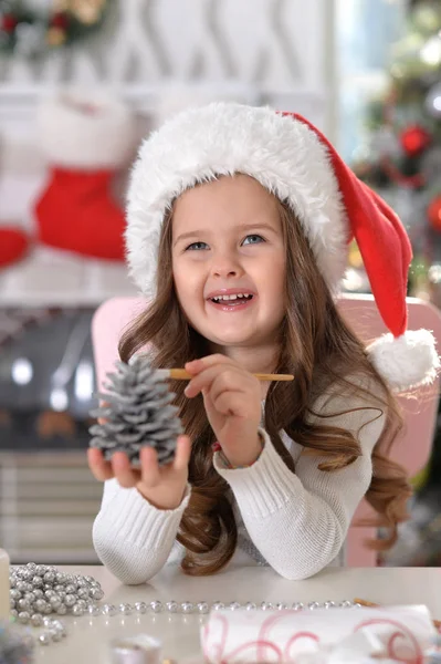 Menina com decoração de cone de pinho — Fotografia de Stock