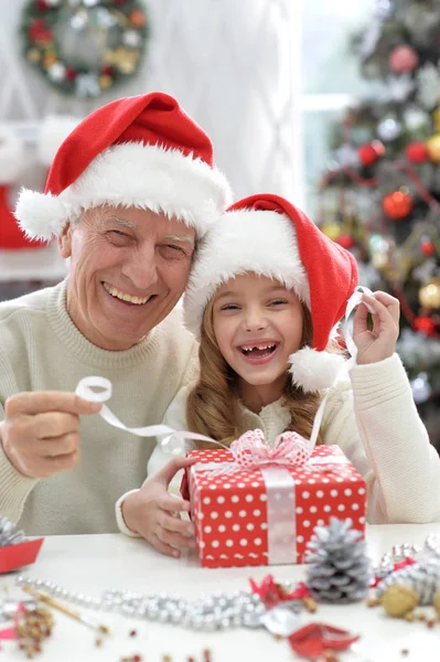 Dědeček a dítě v Santa klobouky — Stock fotografie