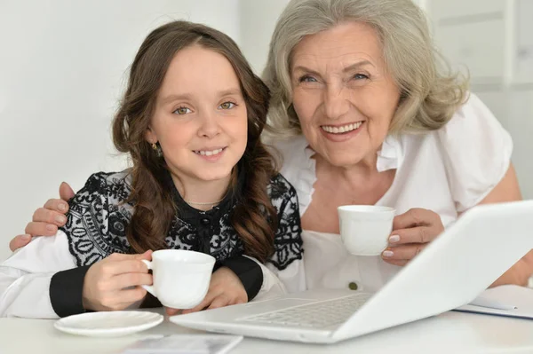 Mormor med barnbarn med laptop — Stockfoto