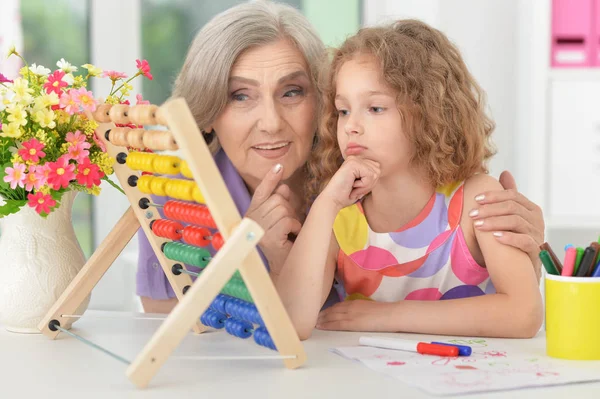 Бабушка помогает внучке делать уроки — стоковое фото