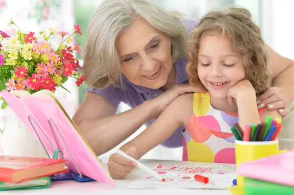 Grootmoeder en kleindochter maken huiswerk — Stockfoto