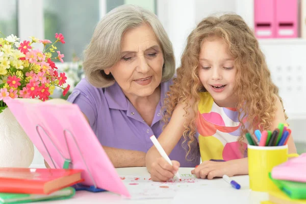 Grootmoeder en kleindochter maken huiswerk — Stockfoto