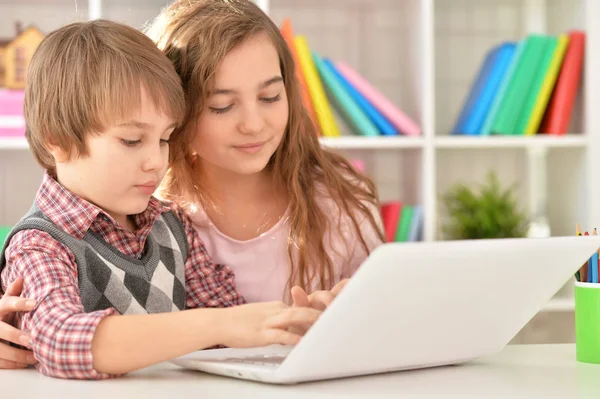 Menino e menina usando laptop — Fotografia de Stock