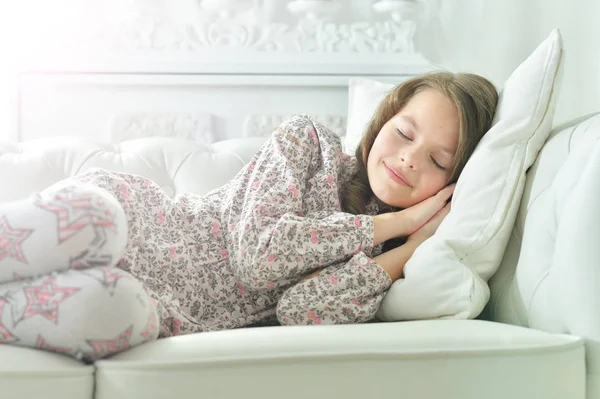 Menina no pijama dormindo no sofá — Fotografia de Stock