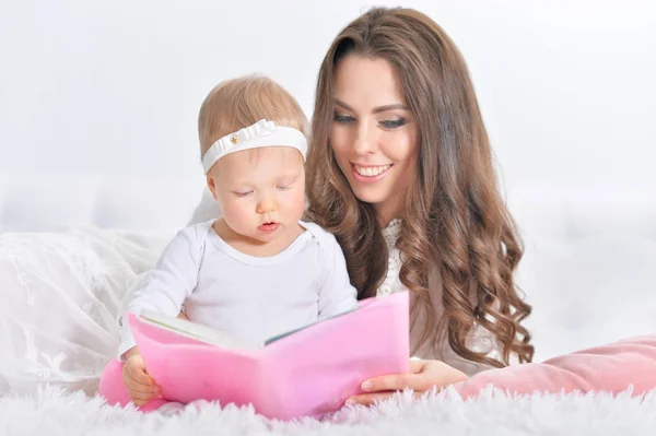 Genç anne ile kızı okuma kitabı — Stok fotoğraf