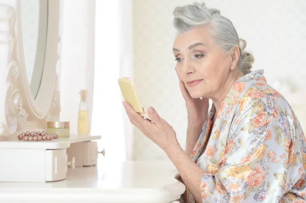 Seniorin schminkt sich — Stockfoto