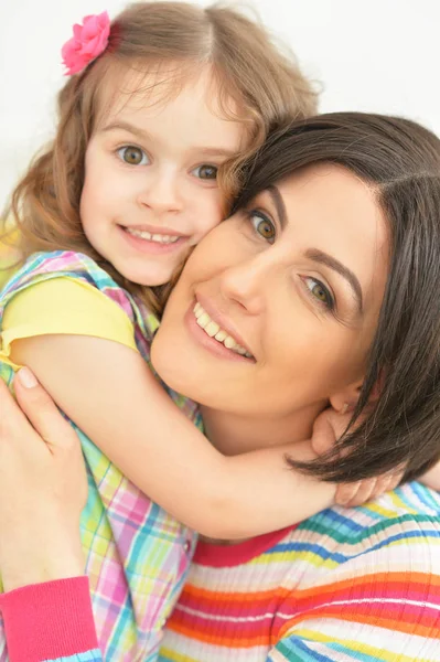 Junge Mutter umarmt ihre kleine Tochter — Stockfoto