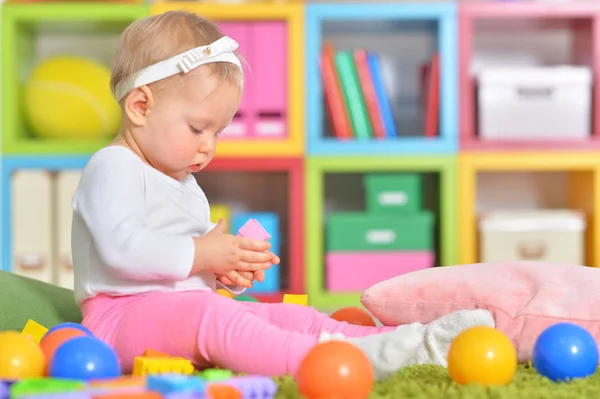 Маленький ребенок играет с красочными игрушками — стоковое фото