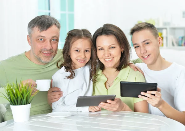 Famiglia seduta a tavola con gadget — Foto Stock