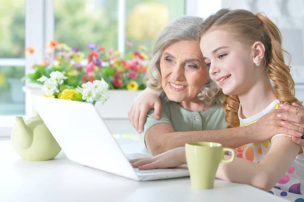 Girl with grandmother using laptop — Stock Photo, Image