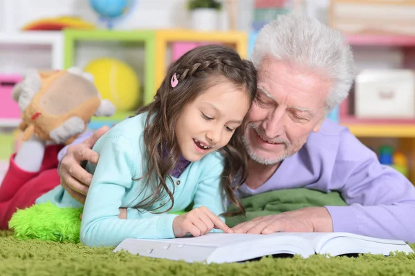 Grootvader leesboek met kleindochter — Stockfoto