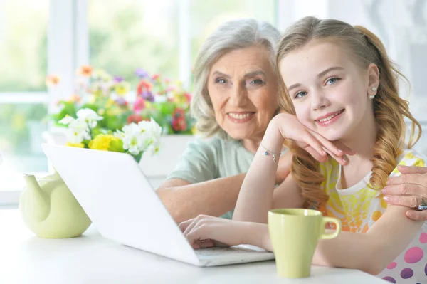 Ragazza con nonna utilizzando il computer portatile — Foto Stock