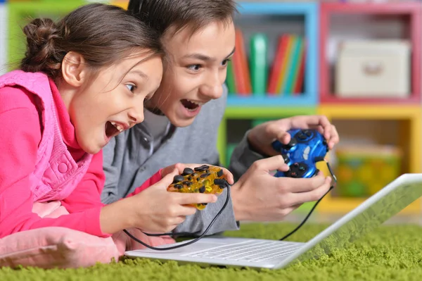 Broer en zus spelen van computerspel — Stockfoto