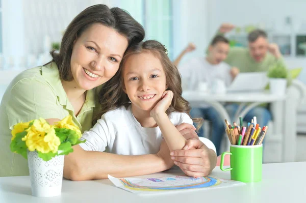 Moeder en dochter zitten aan tafel — Stockfoto