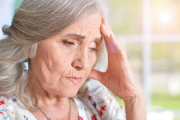 Seniorin mit Kopfschmerzen — Stockfoto