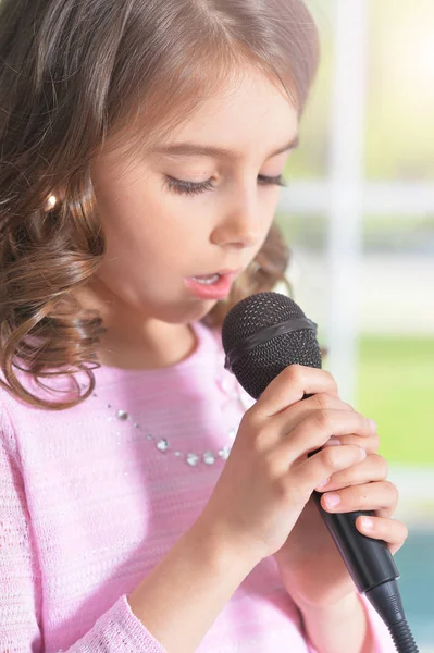 Mała dziewczynka śpiewa z mikrofonem — Zdjęcie stockowe