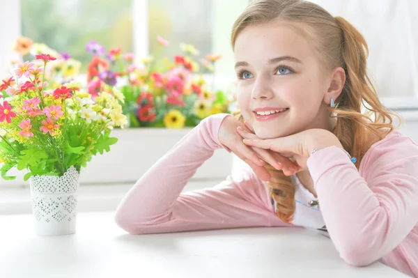 Kleines Mädchen sitzt am Tisch — Stockfoto