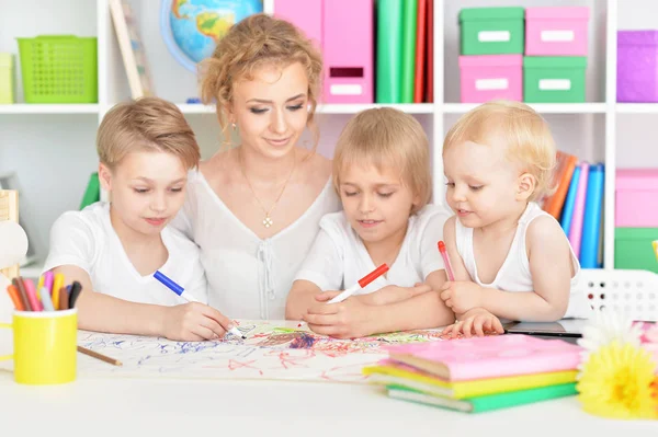 Mutter zeichnet mit drei süßen Söhnen — Stockfoto