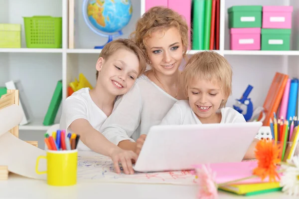 Mamma med söner använder laptop — Stockfoto