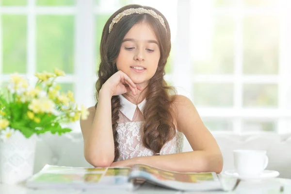 Pequena menina bonito leitura revista — Fotografia de Stock