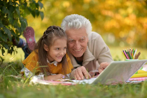 Mädchen und Großvater mit Laptop — Stockfoto